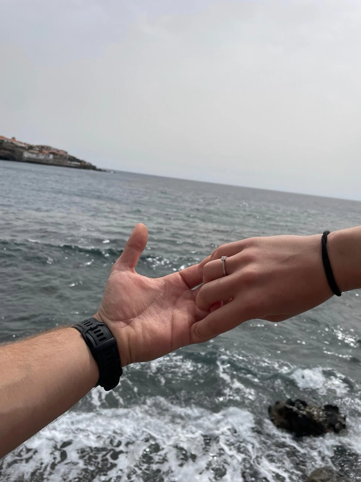 Manos con el anillo junto al mar
